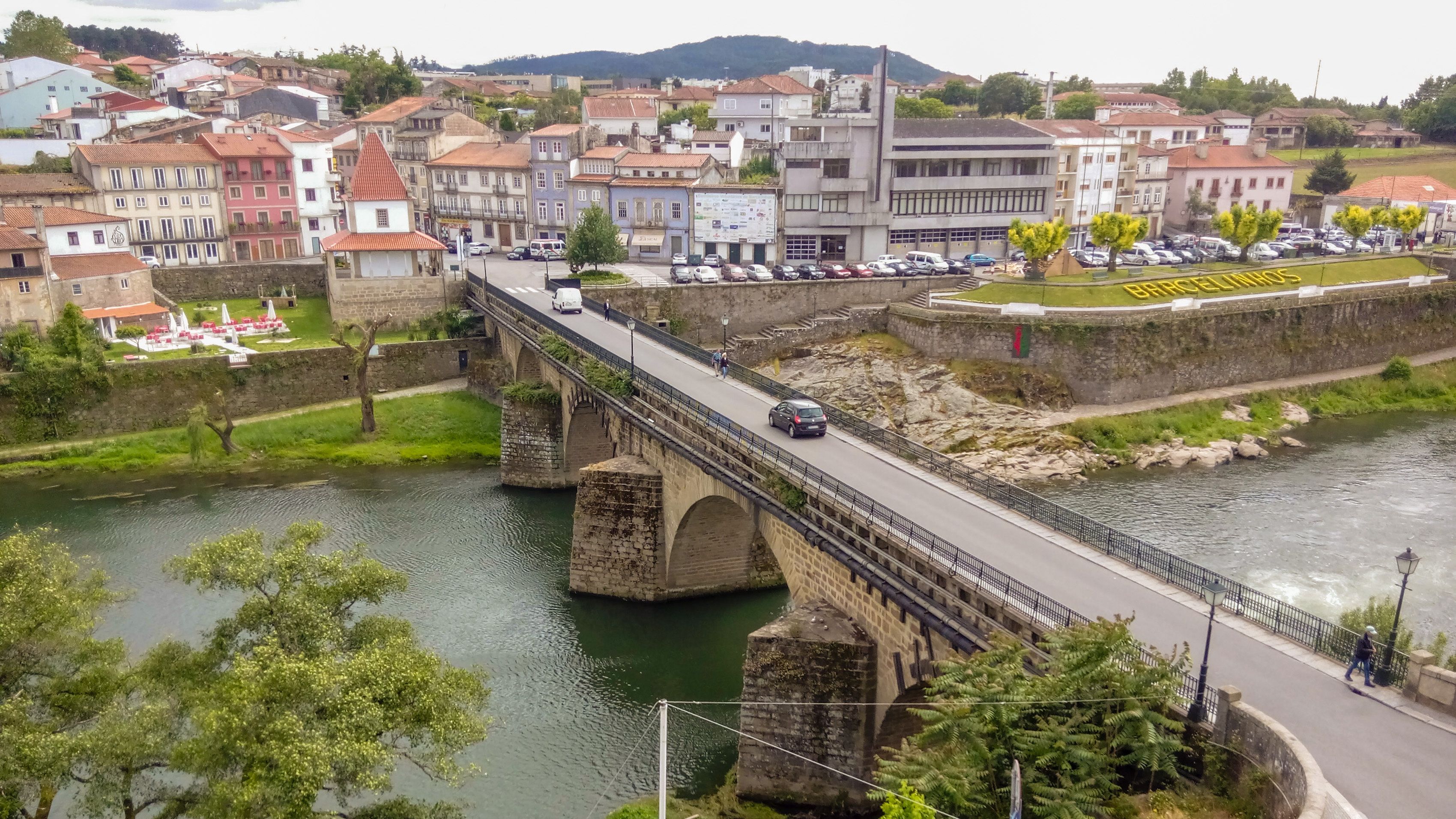 Un puente de piedra sobre un río, rodeado de edificios y vegetación.