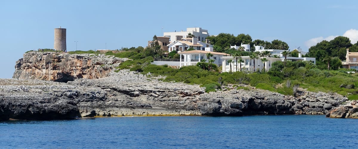 Hafeneinfahrt von Porto Cristo mit dem Torre del Serral dels Falcons in der Gemeinde Manacor, Mallorca, Spanien
