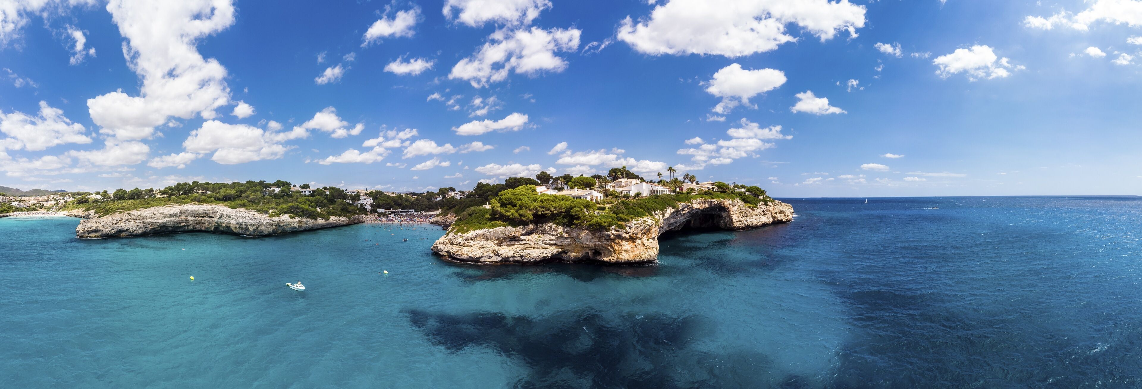 A coastal landscape with rocky formations and clear blue waters.