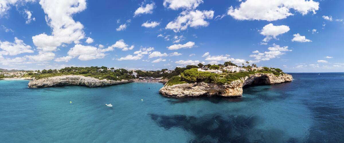 A coastal landscape with rocky formations and clear blue waters.