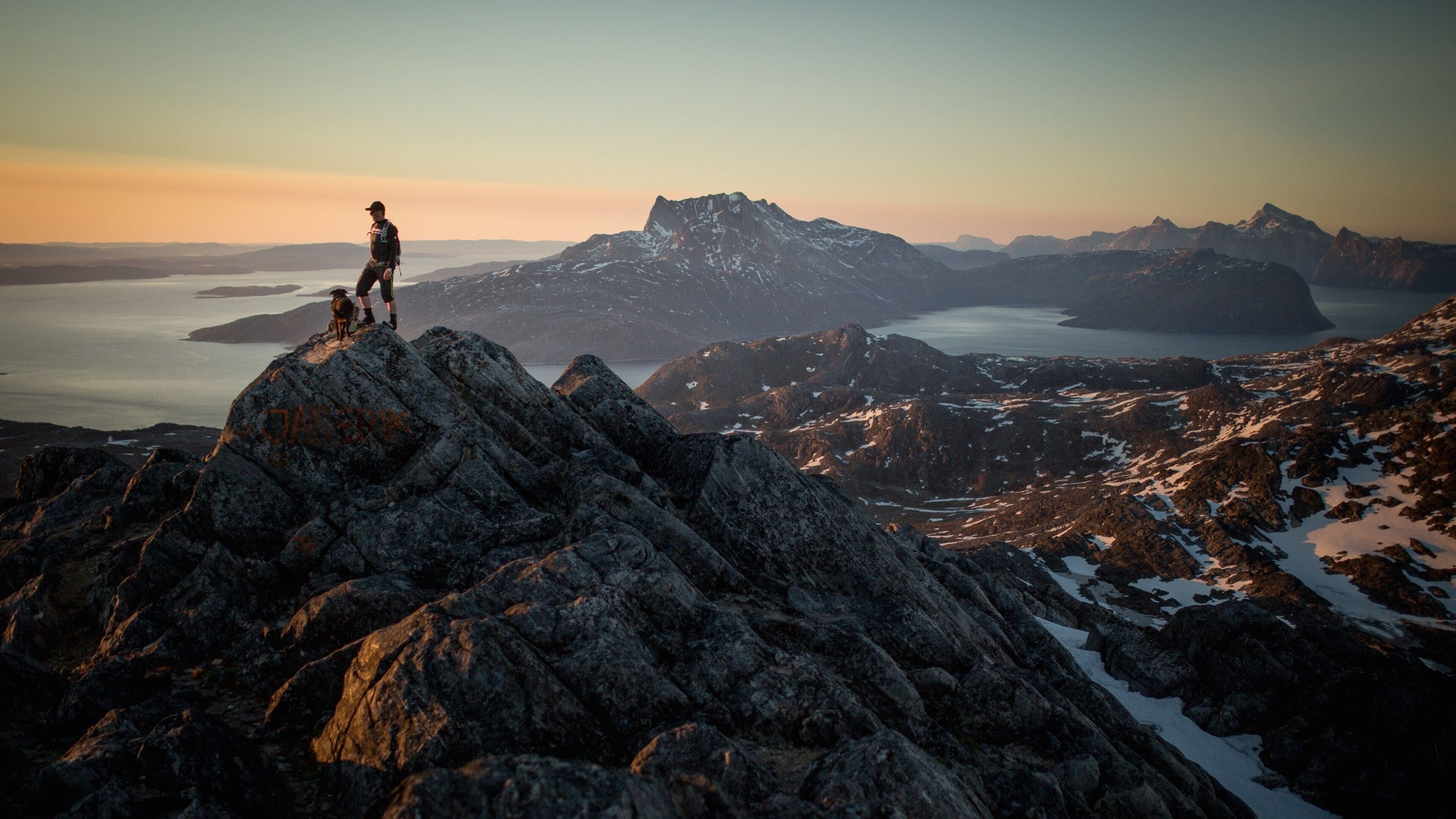 Greenland which includes a lake or waterhole, mountains and snow