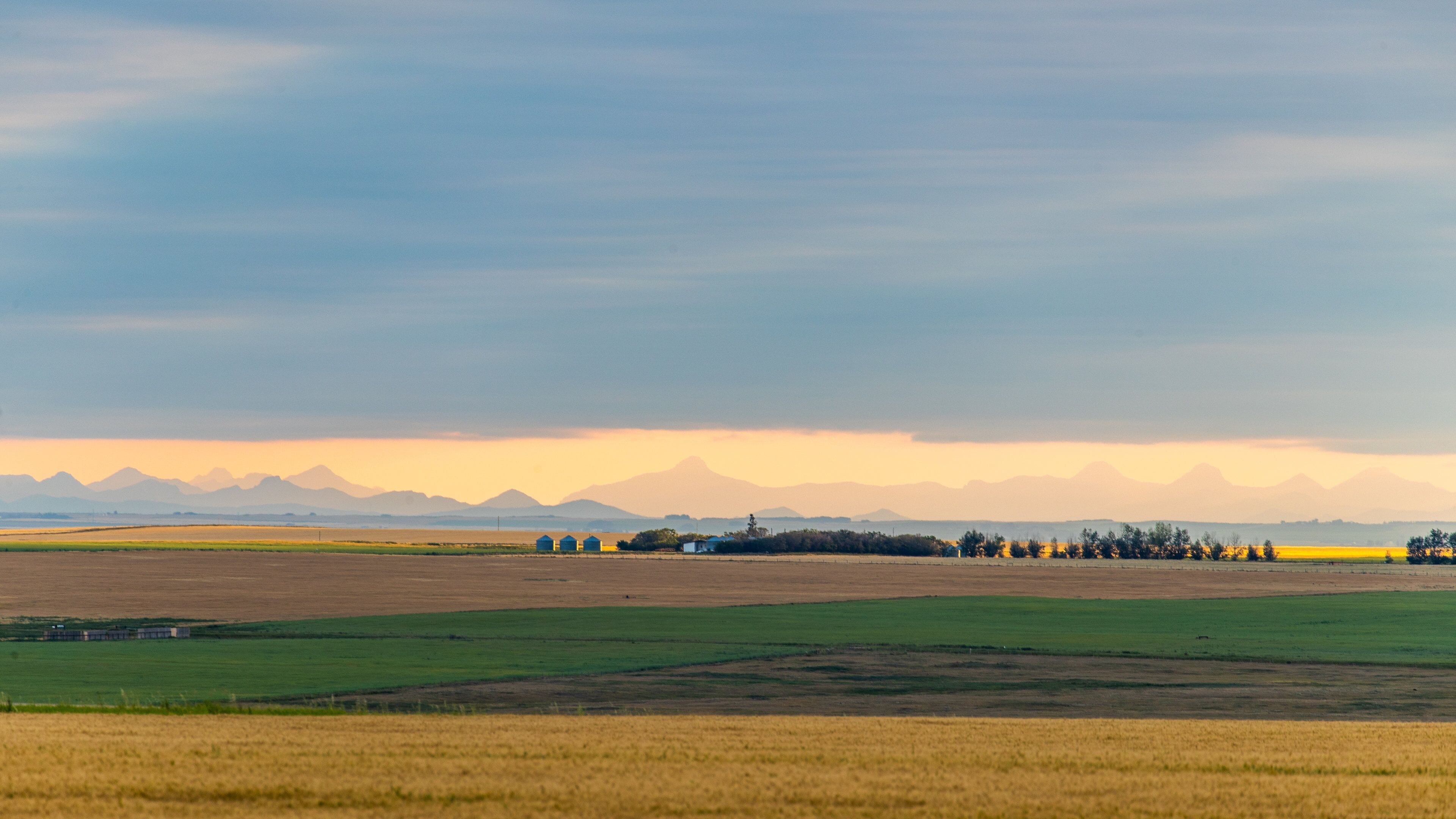 Alberta featuring farmland and a sunset