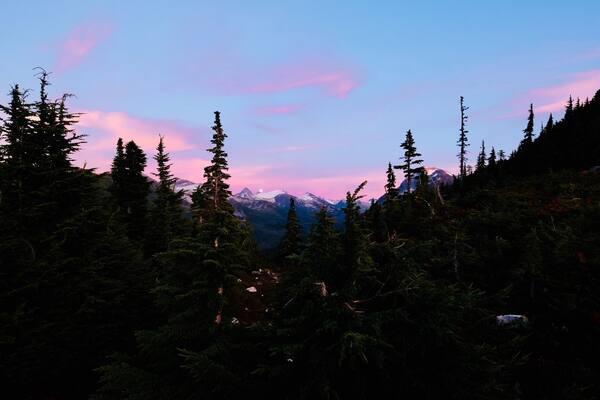 Eine bewaldete Berglandschaft bei Sonnenuntergang.