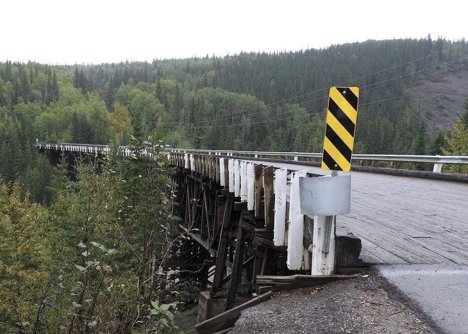 Construction of the Historic Kiskatinaw Bridge began in late 1942. It was one of 133 permanent bridges constructed by the US Public Roads Administration (PRA) to replace the temporary crossings used by the US Army to build the pioneer road. This three-span timber truss bridge has an amazing nine-degree curve – a curve that PRA engineers designed to accommodate the highway’s steep change in grade on the west end and the need to land at a notch in the cliff on the east end. At the time, it was the first wooden curved bridge to be built in Canada. Development of the oil and gas industry in the post war years resulted in the need for a new bridge to handle wider and heavier loads; as a result, the Alaska Highway was rerouted in 1978, bypassing approximately 10 km of the old highway and the historic bridge.

#historic #bridge #GreatOutdoors #OnTheRoad