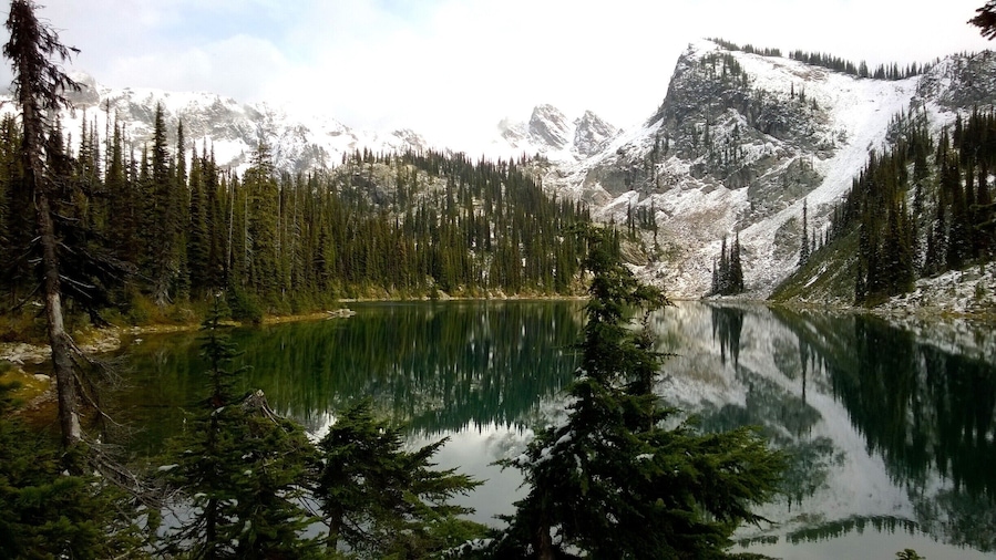 A late fall hike to Eva Lake in Revelstoke National Park, British Columbia. While hiking in, the moutain top received it's first snow flurry of the season. After the snow settled, the sky cleared and left us with this stunning view!