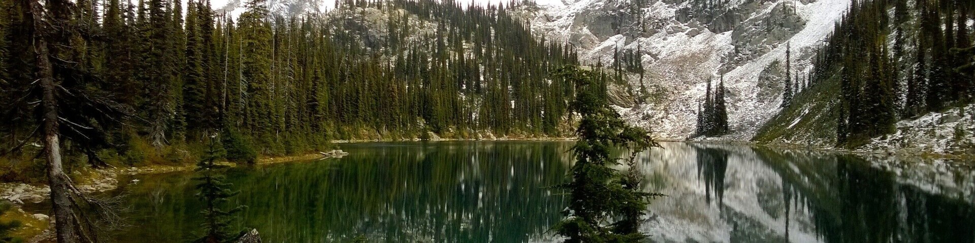 A late fall hike to Eva Lake in Revelstoke National Park, British Columbia. While hiking in, the moutain top received it's first snow flurry of the season. After the snow settled, the sky cleared and left us with this stunning view!