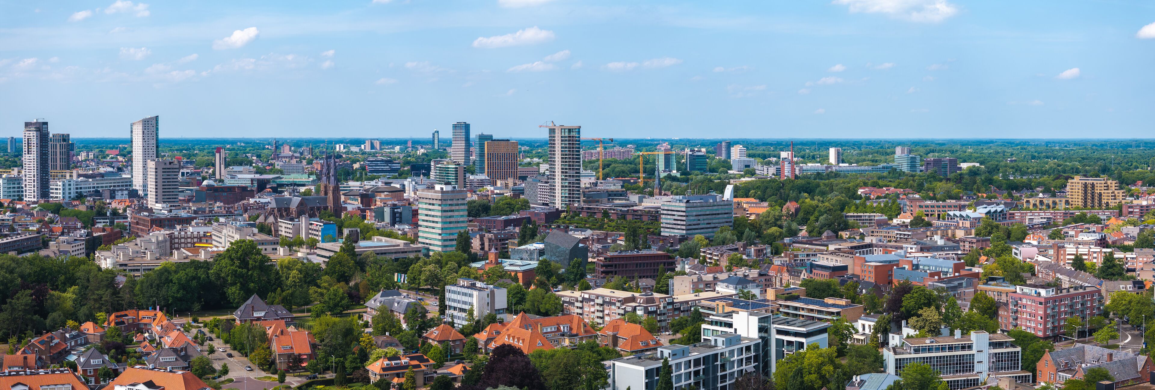 A cityscape with a mix of modern and traditional architecture, including high-rise buildings and historic houses.