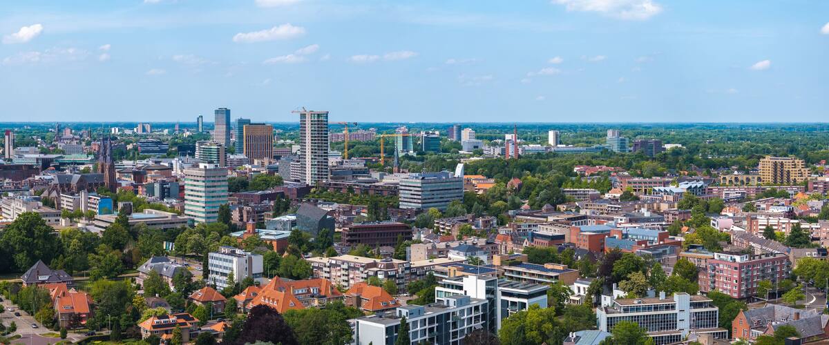 A cityscape with a mix of modern and traditional architecture, including high-rise buildings and historic houses.