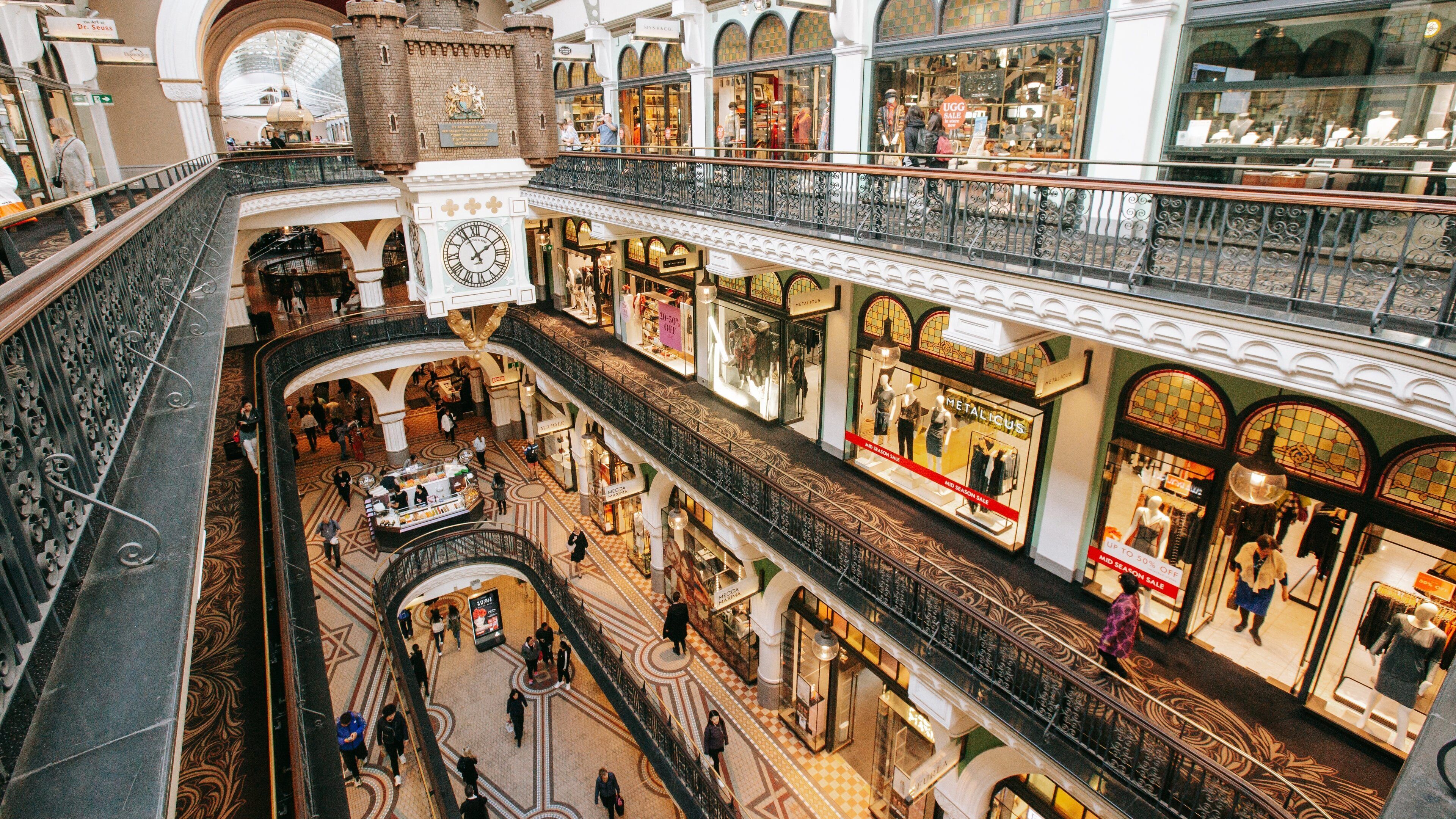 A multi-level shopping mall with ornate architecture, including a clock tower and a castle-like structure.