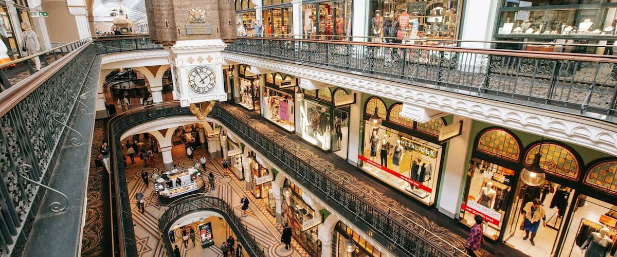 A multi-level shopping mall with ornate architecture, including a clock tower and a castle-like structure.