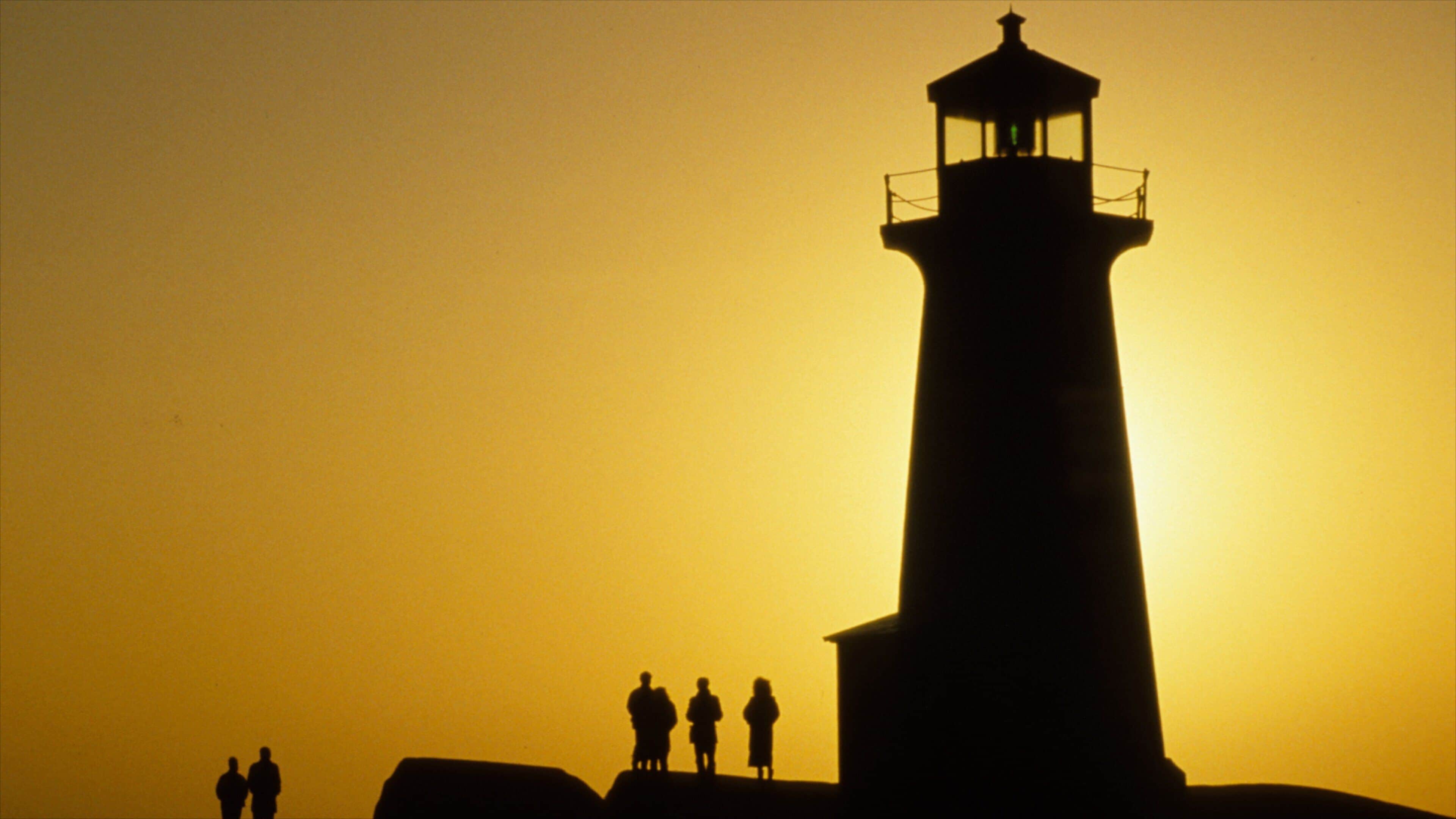 Nova Scotia showing a sunset and a lighthouse as well as a small group of people