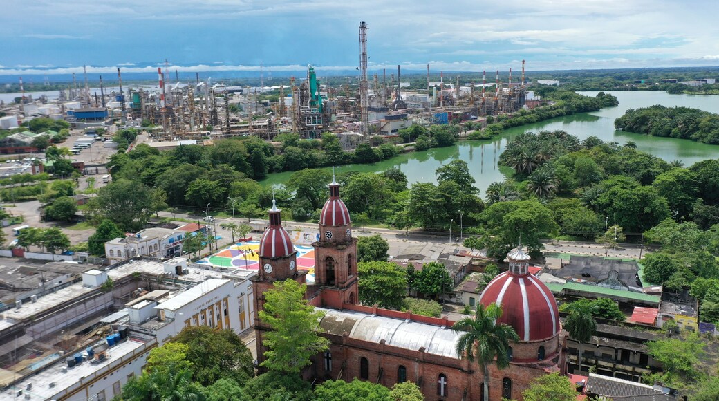 Domes of a church with an oil refinery plant in the background in the city of Barrancabermeja. Colombia.