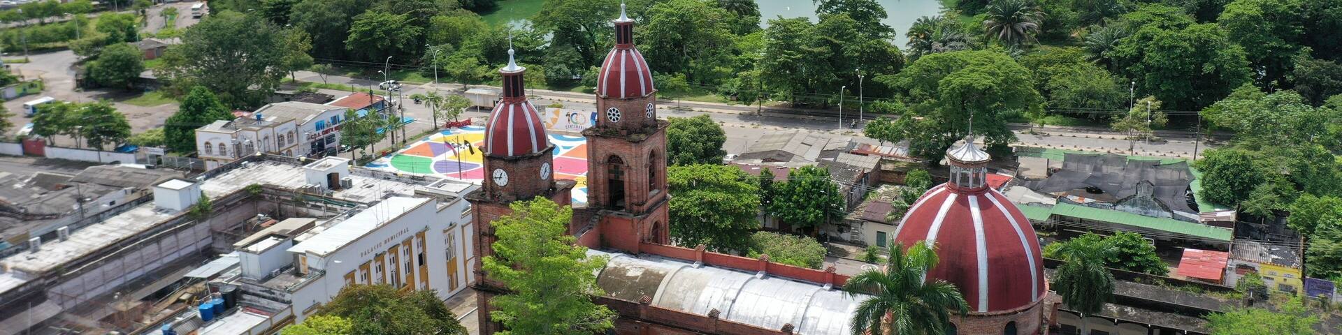 Domes of a church with an oil refinery plant in the background in the city of Barrancabermeja. Colombia.