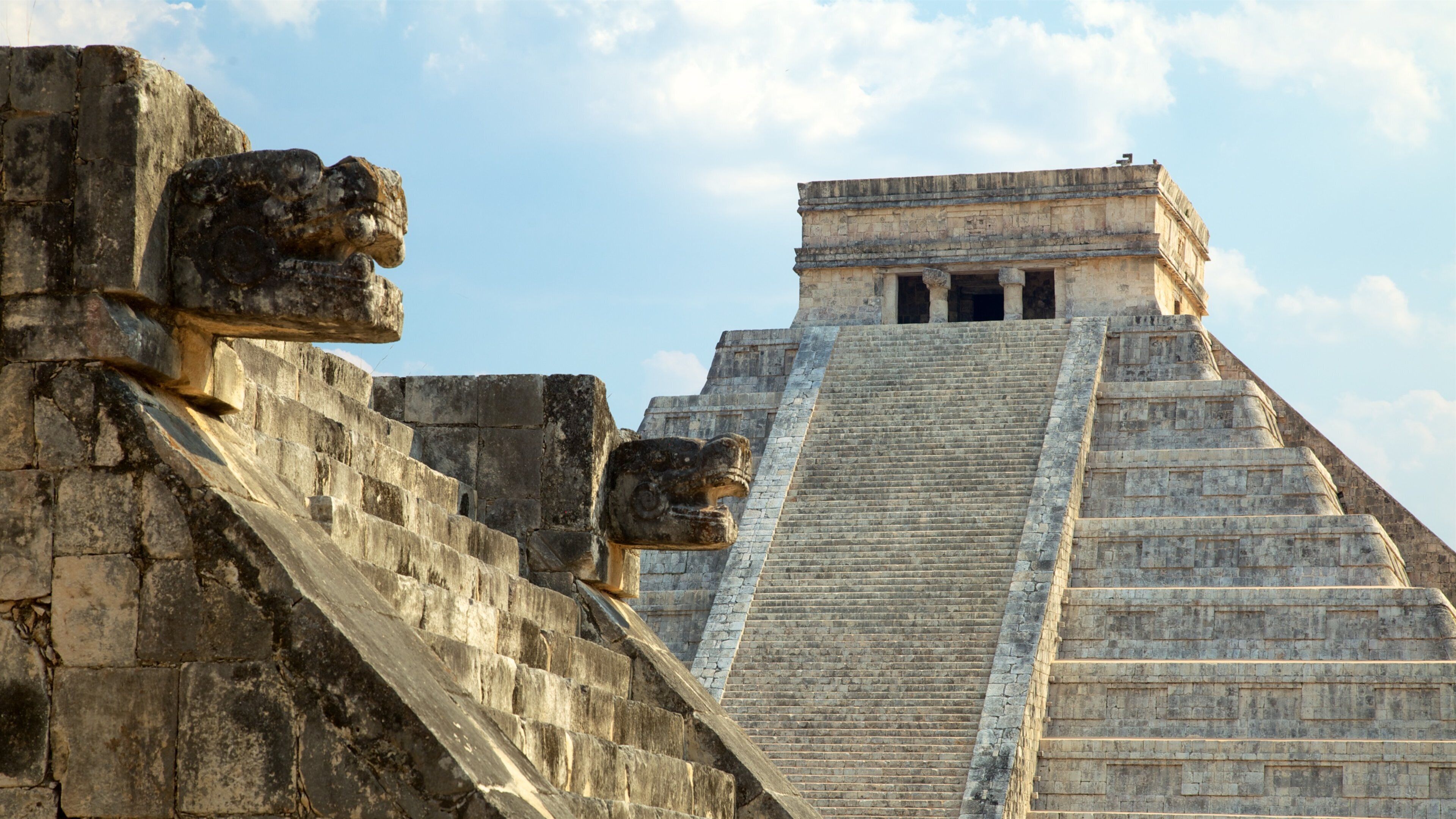 A pyramid with stone carvings and a staircase leading to the top.