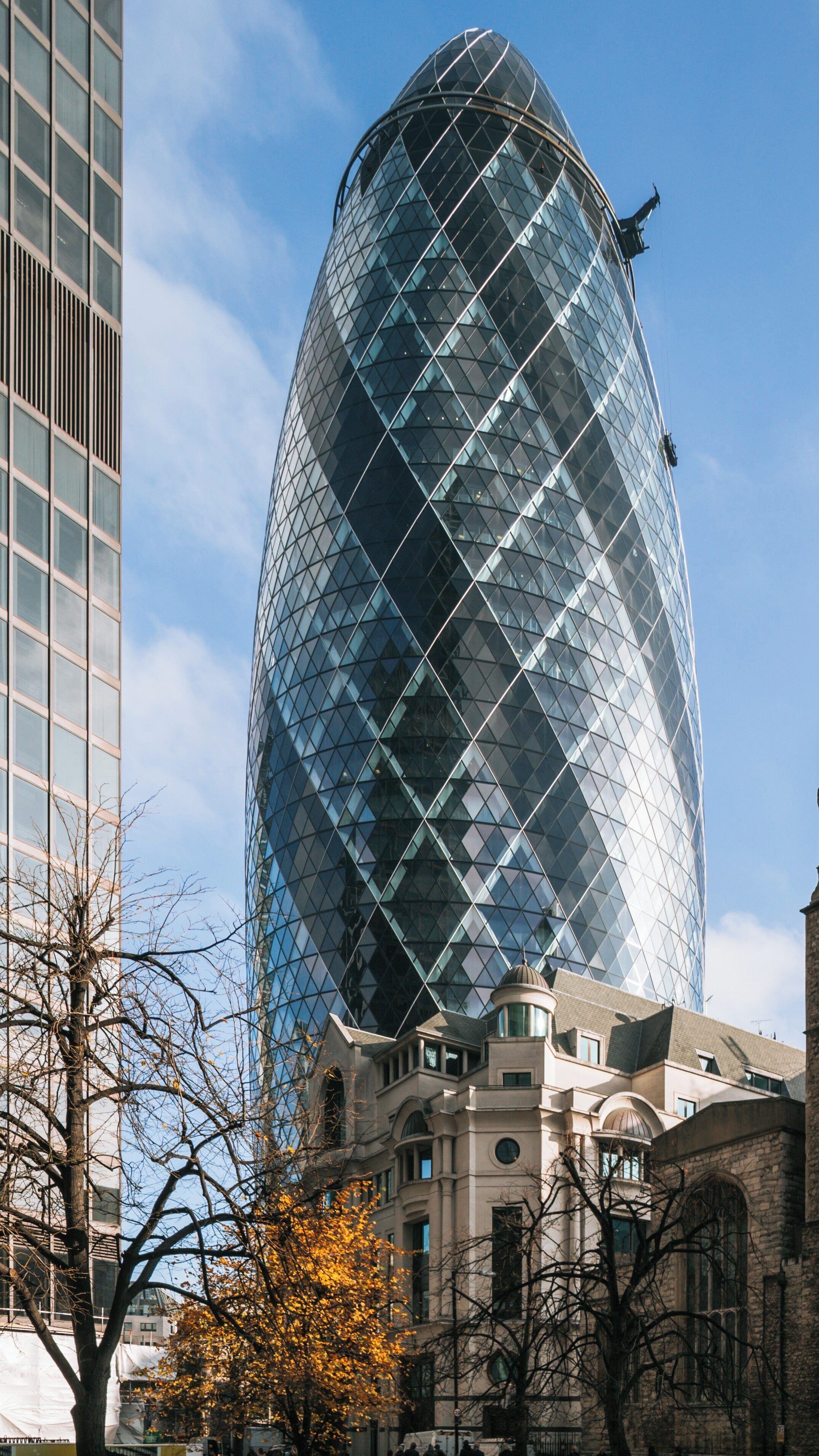 Iconic Gherkin structure rises above historic architecture in London City Centre, showcasing modern design in the heart of England