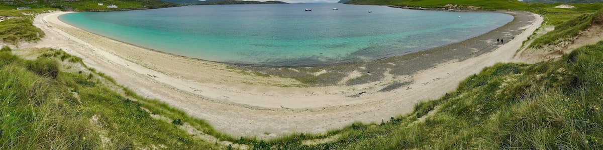 Vatersay East Beach faces the mainland of Scotland and the Isle of Skye with the small Isles to the south. Vatersay East is calmer than it's close neighbor the west side, the perfect places to catch a sunrise on one side and a sunset on the other, Vatersay is now connected by a causeway to the larger Island of Barra to the north.
https://www.undiscoveredscotland.co.uk/vatersay/vatersay/index.html