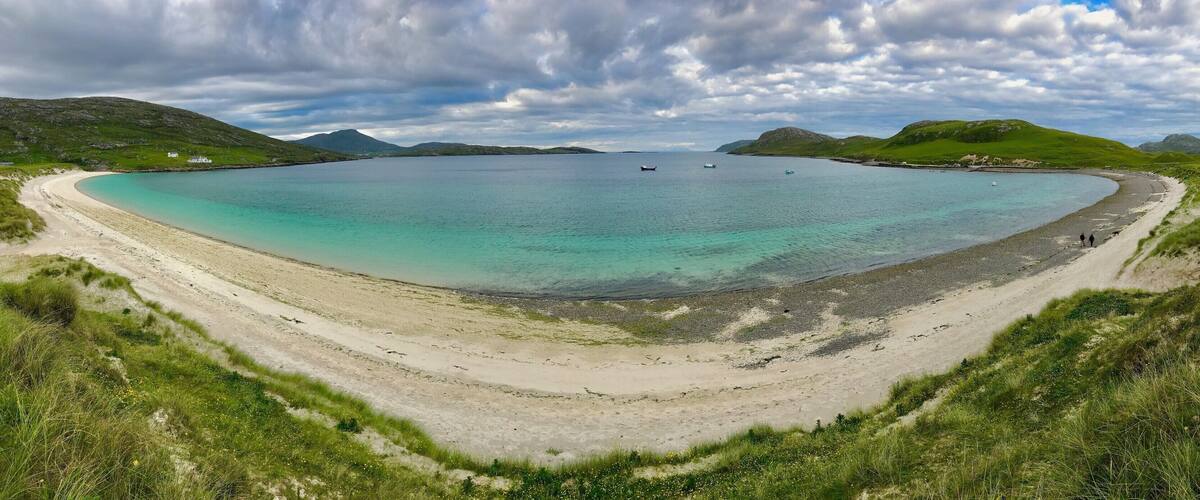 Vatersay East Beach faces the mainland of Scotland and the Isle of Skye with the small Isles to the south. Vatersay East is calmer than it's close neighbor the west side, the perfect places to catch a sunrise on one side and a sunset on the other, Vatersay is now connected by a causeway to the larger Island of Barra to the north.
https://www.undiscoveredscotland.co.uk/vatersay/vatersay/index.html