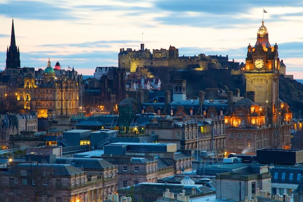 A historic cityscape with a prominent castle and clock tower.