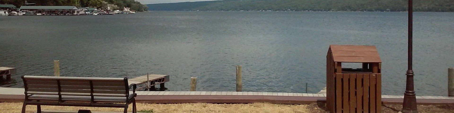 Un banco junto al lago, una estructura de madera y un farol cerca del agua.