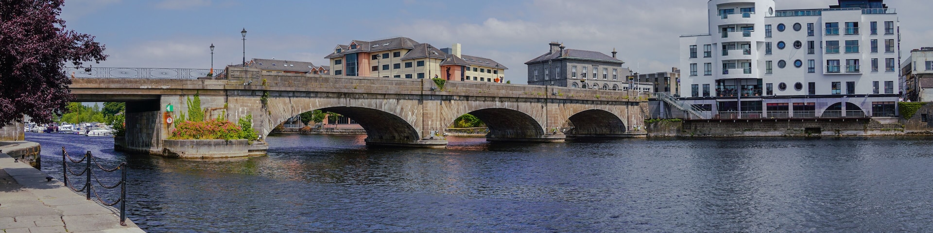A stone bridge over a river, with buildings on either side.