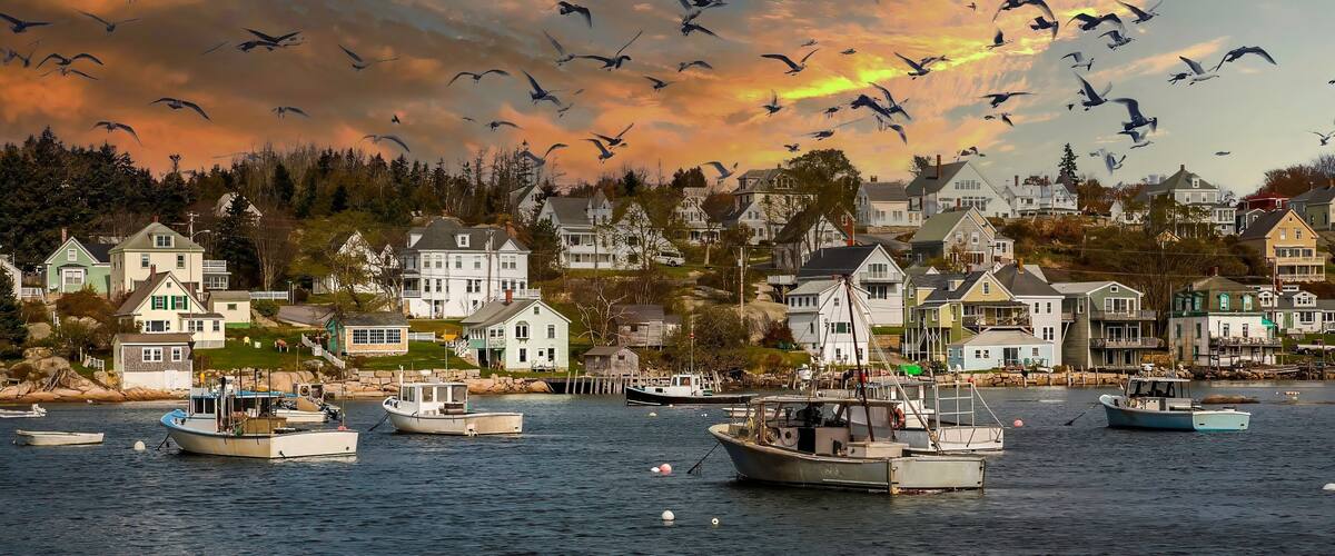 A coastal village with houses and boats on the water.