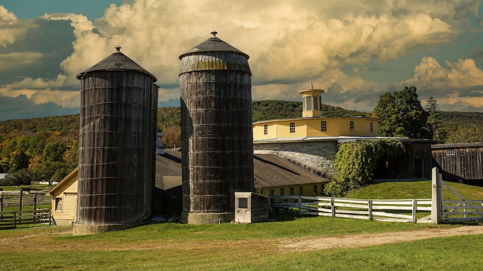 Round barn and two wooden silos on a farm near Hancock, MA.