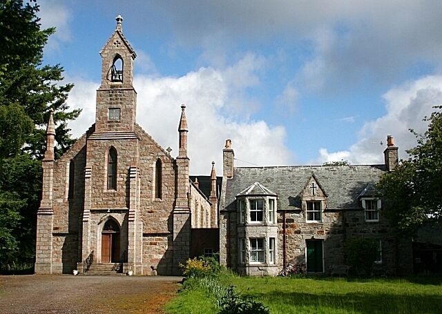 A stone church with a bell tower and a smaller attached building.