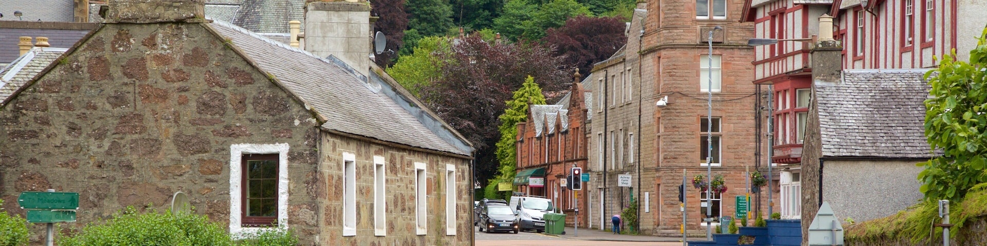A stone building with a pointed roof and a sign indicating 'Meadows'.