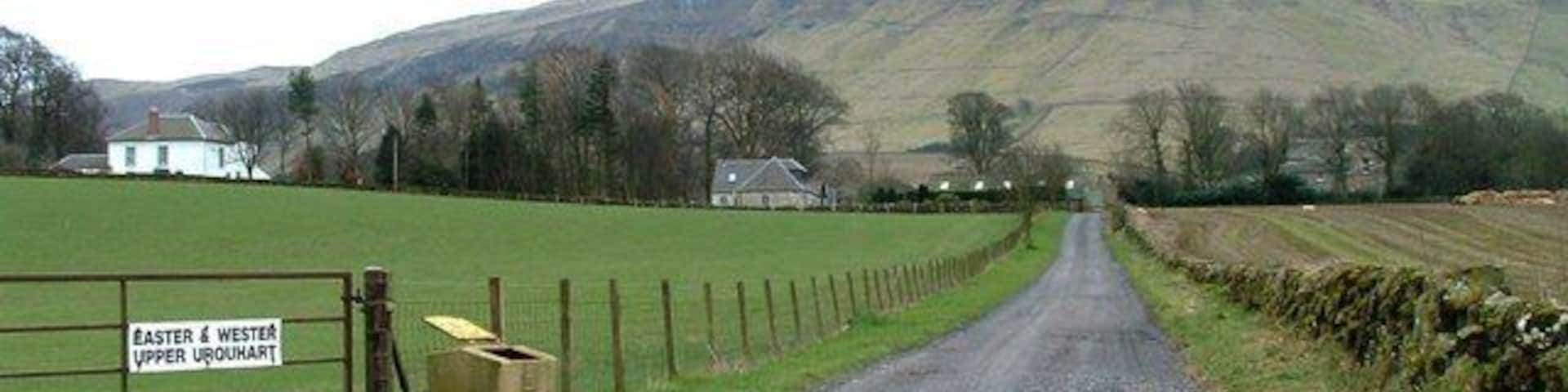 Un camino rural que conduce a una puerta con la inscripción 'Easter & Wester Upper Urquhart'.
