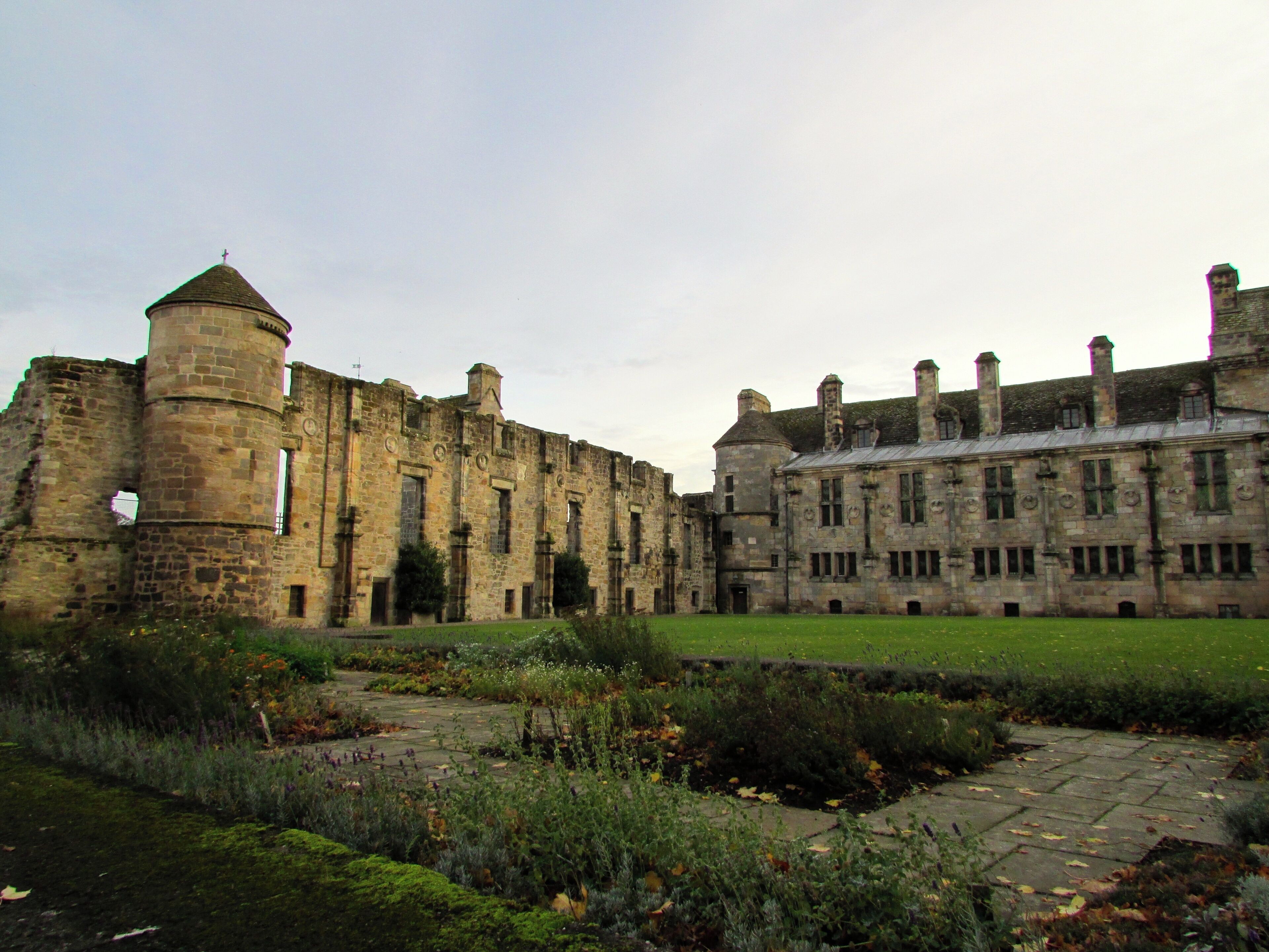 A historic stone building with a tower and a large courtyard.