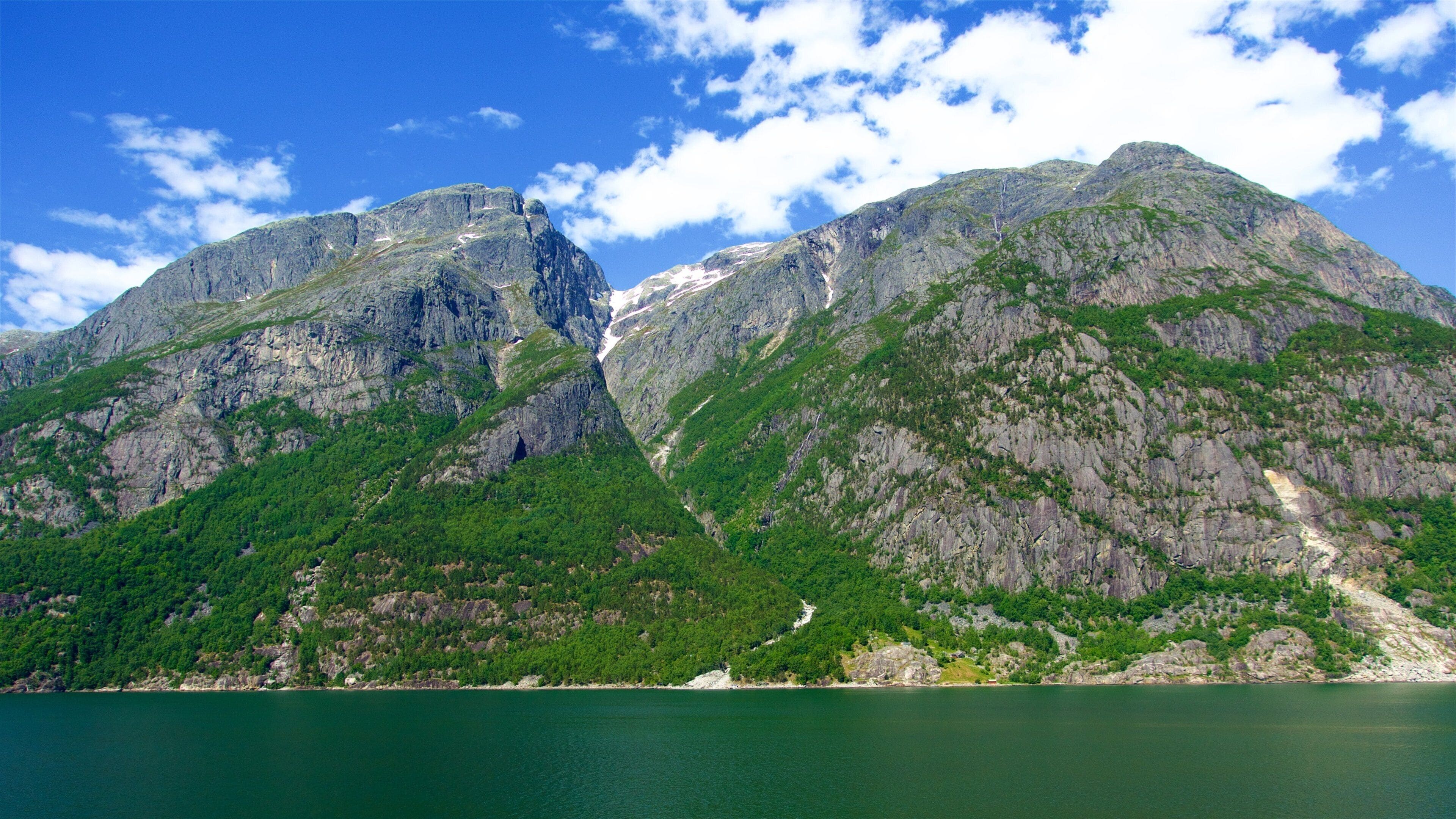 A mountain range with a lake in the foreground.