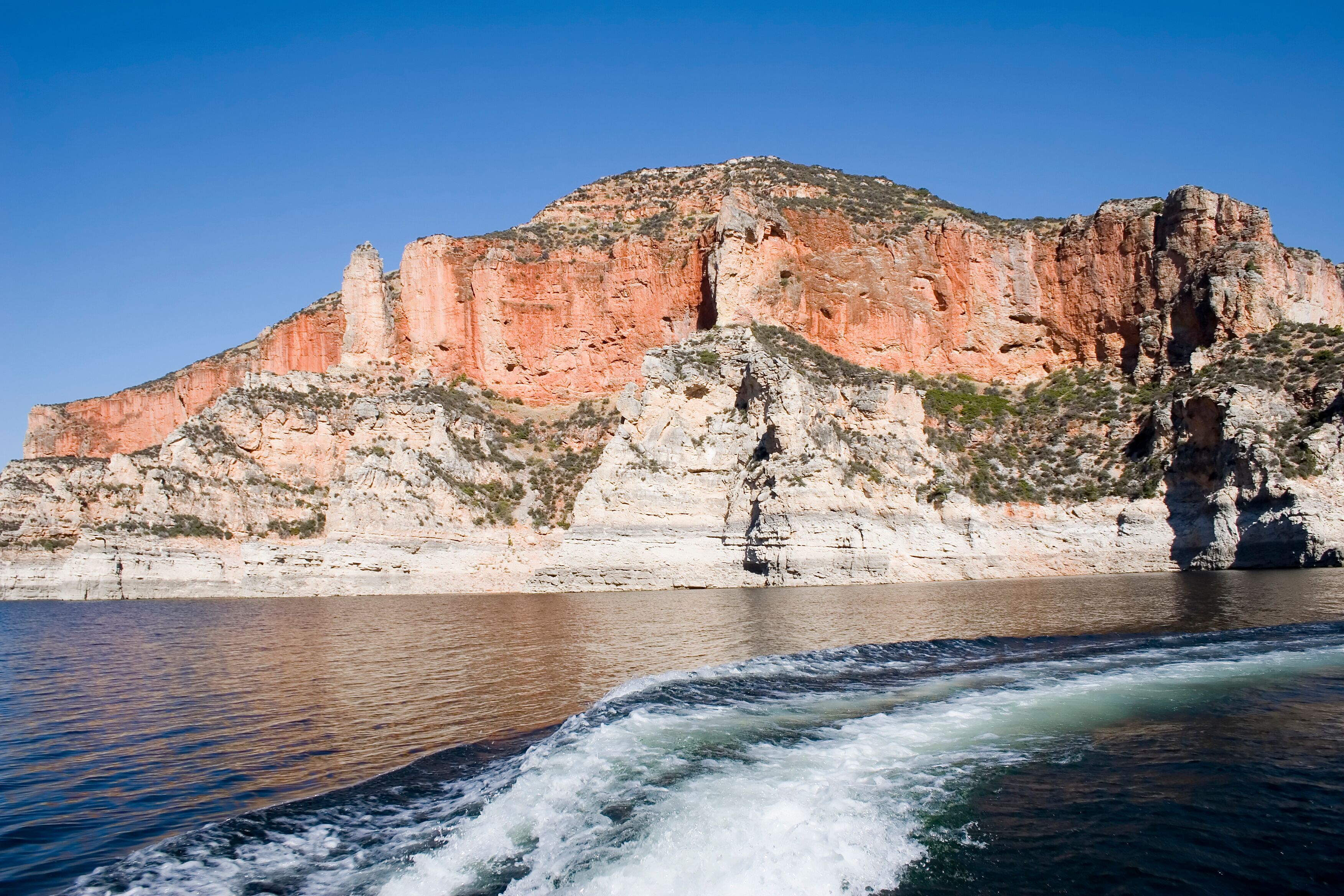 A rocky cliff with a river flowing in front.