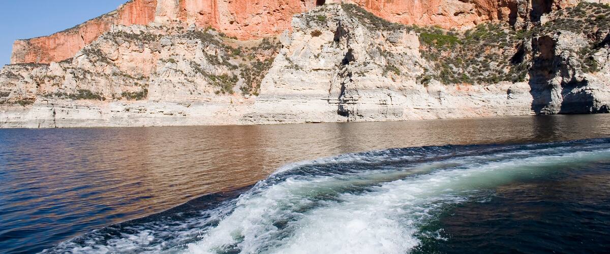 A rocky cliff with a river flowing in front.