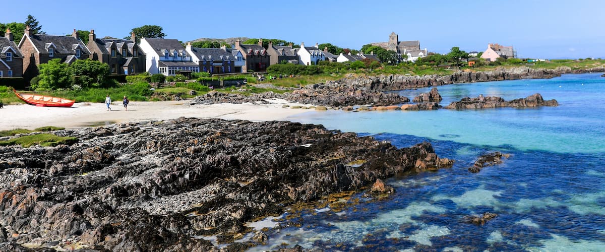 A coastal town with houses, a beach, and rocky shores.