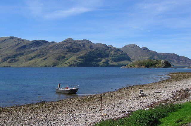 Camus Ban, Arnisdale. Beach at Arnisdale. The boat is the one used to ferry folk to and from the north shore of Knoydart - visible across Loch Hourn.