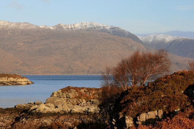 A lake surrounded by mountains with snow-capped peaks.