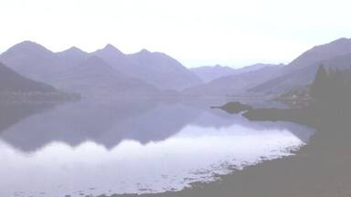 A calm lake surrounded by mountains.