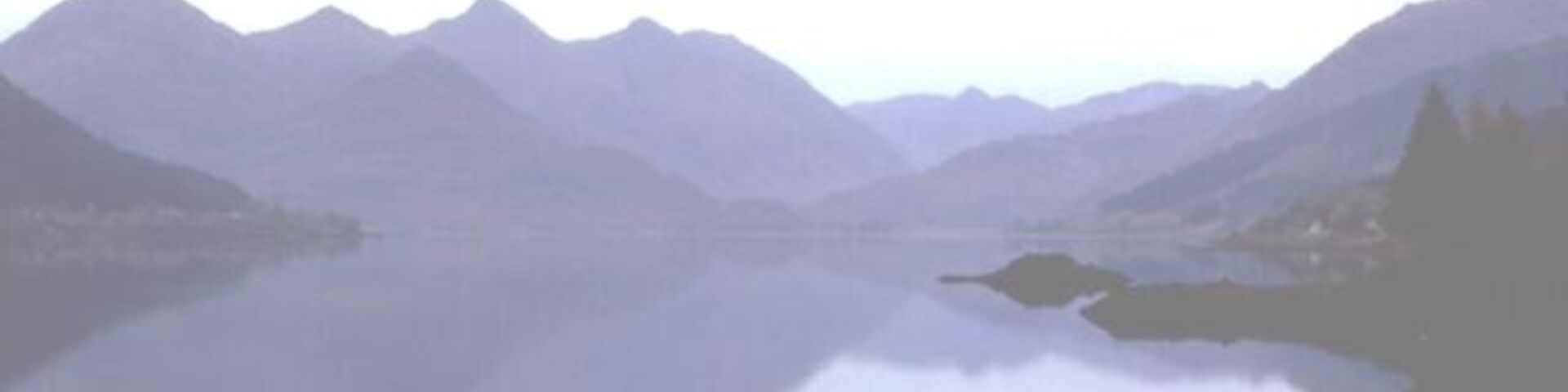 A calm lake surrounded by mountains.