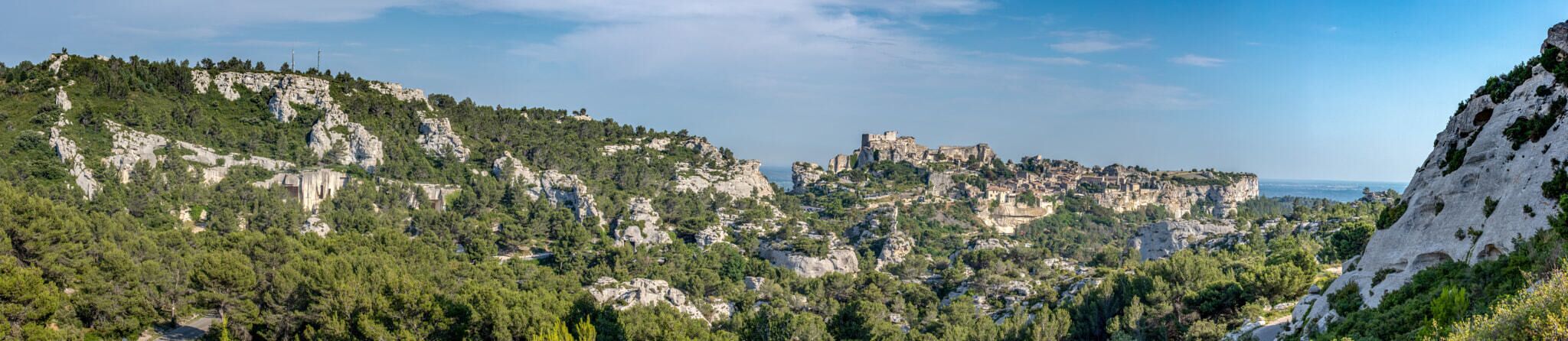 A mountainous landscape with rocky cliffs and a historic castle on a hill.