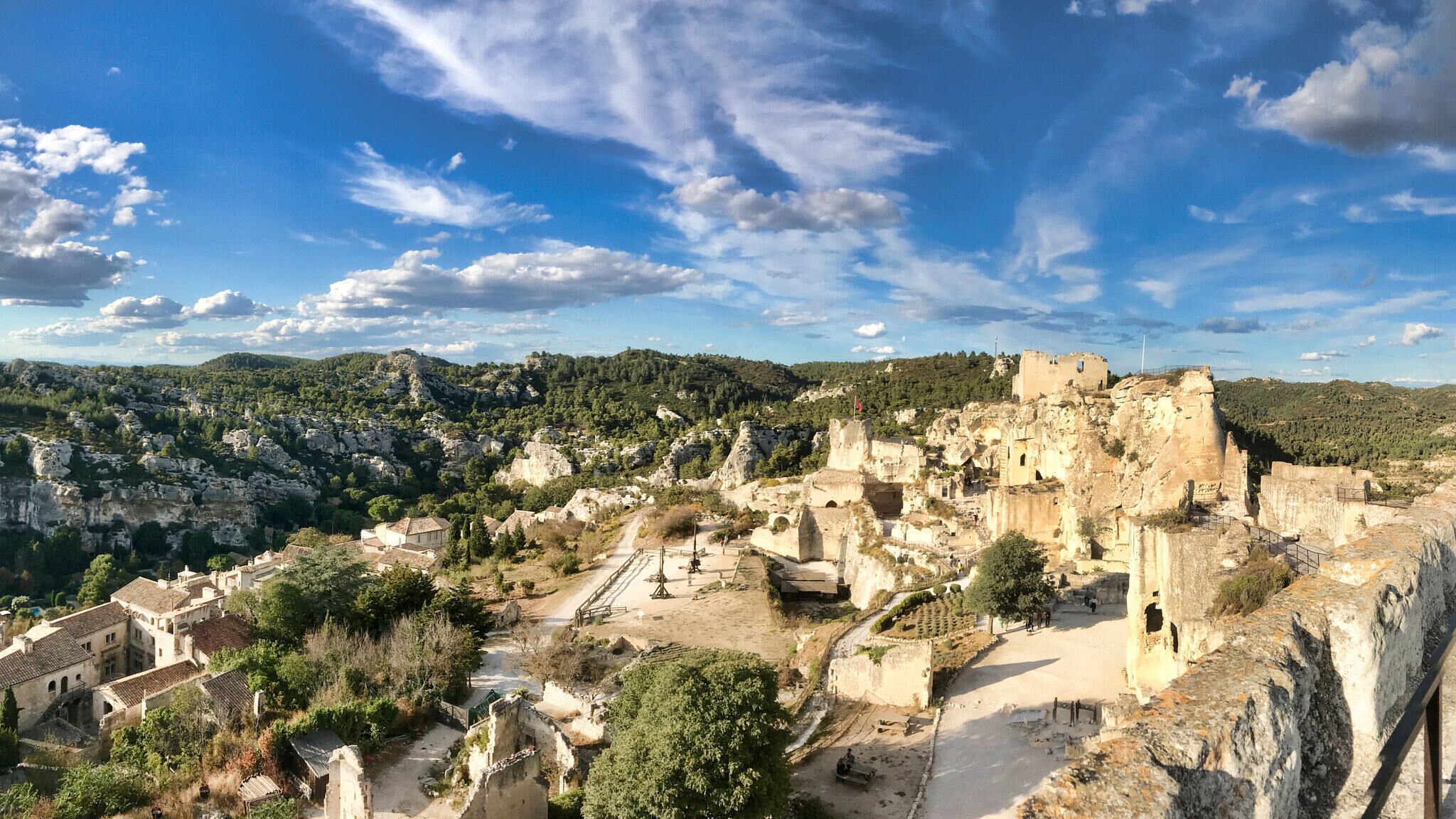 A historic town with ancient ruins and a castle on a hill.