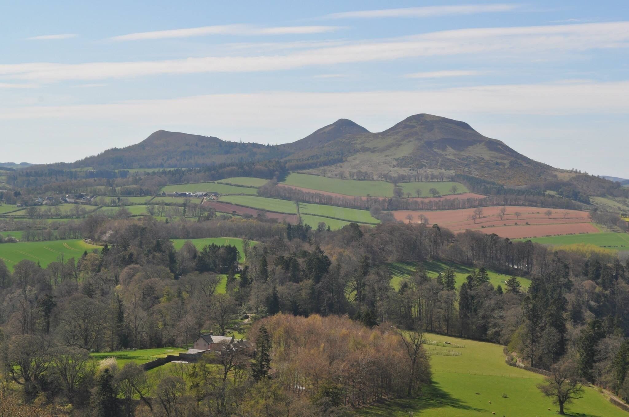 Rolling hills, a small village, and a mountain range.