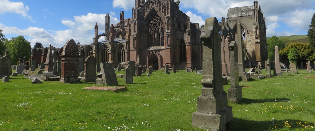 Una iglesia histórica de arquitectura gótica rodeada por un cementerio.