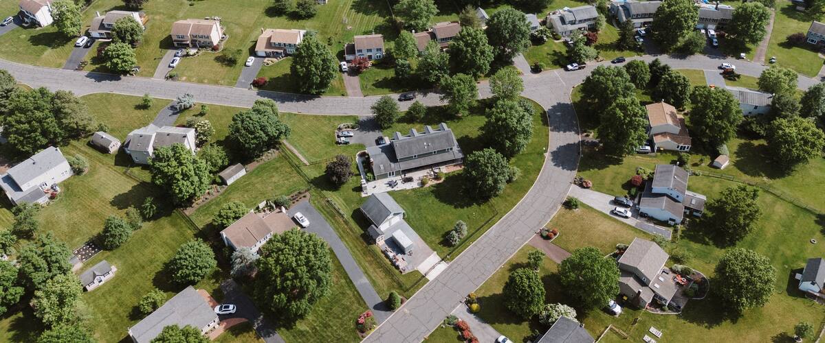 An aerial view of a residential neighborhood with houses, roads, and green spaces.