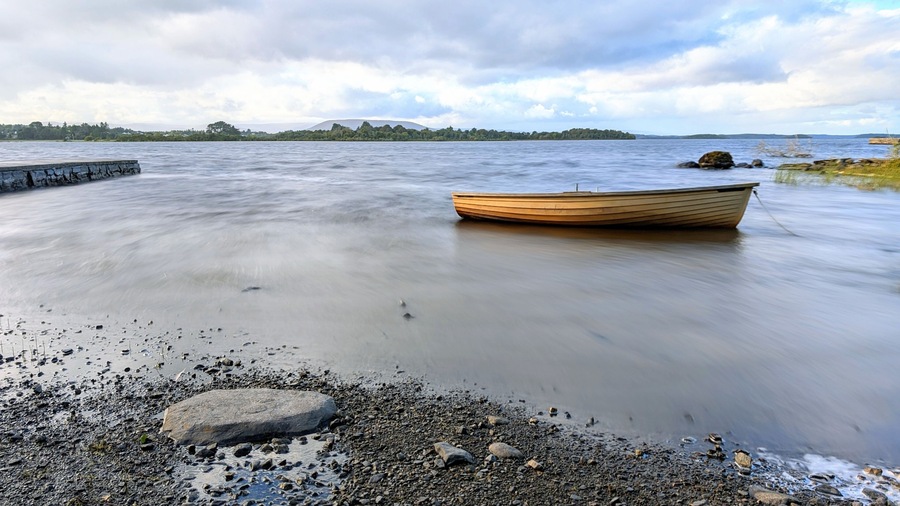 Beautiful lakeside landscape scenery, old wooden fishing boat by Oughterard pier on Corrib lake, Galway, Ireland, nature background