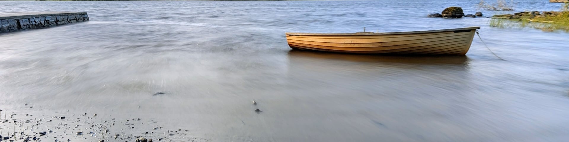 Beautiful lakeside landscape scenery, old wooden fishing boat by Oughterard pier on Corrib lake, Galway, Ireland, nature background