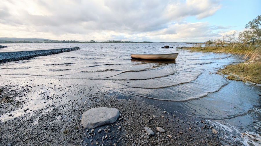 Beautiful lakeside landscape scenery, old wooden fishing boat by Oughterard pier on Corrib lake, Galway, Ireland, nature background