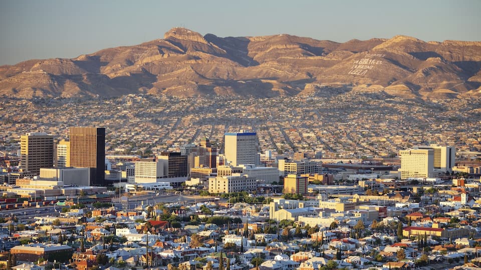 A cityscape with a mountain range in the background.