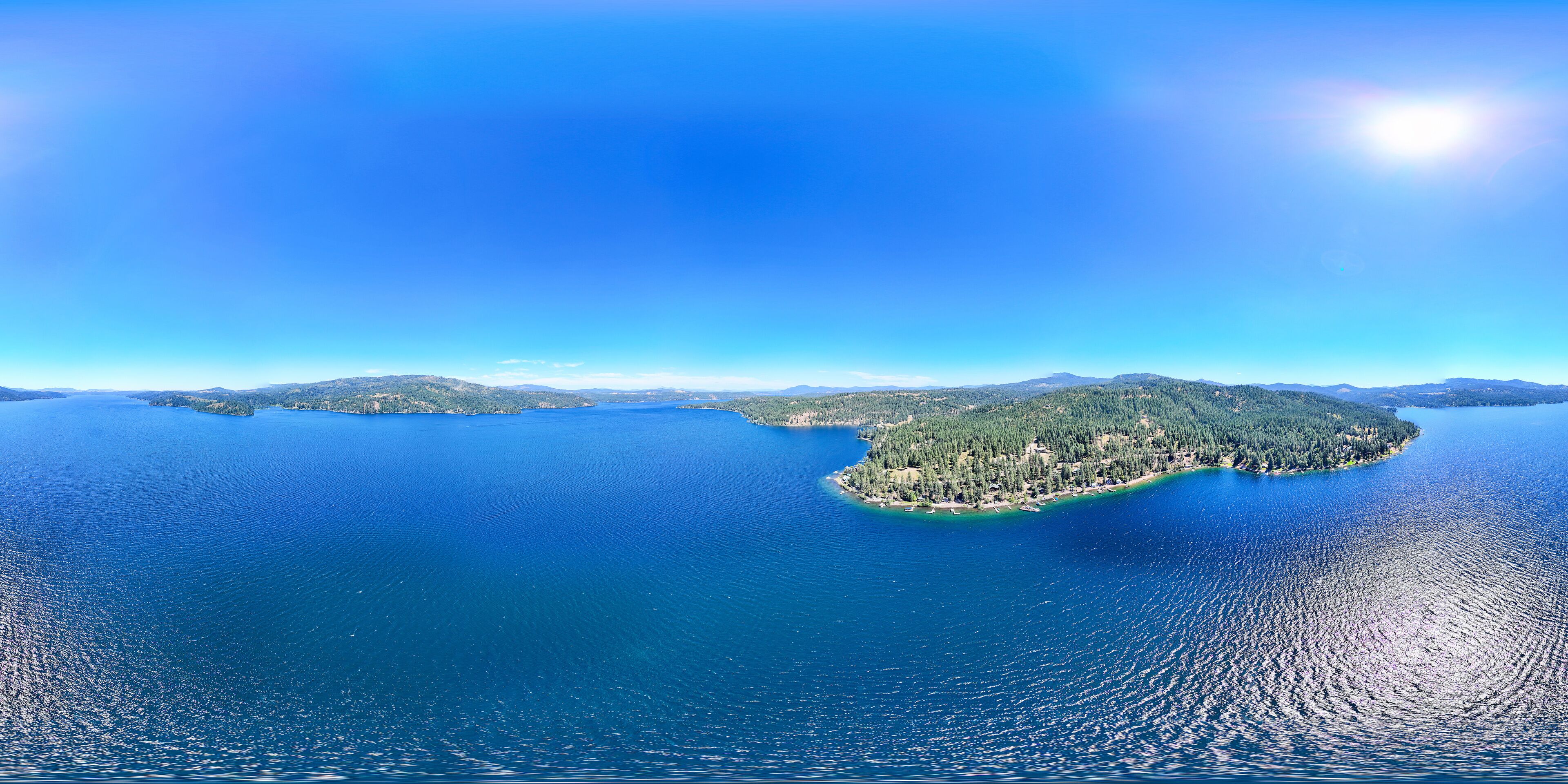 Aerial view captured by drone of the deep blue water at lake coeur d'alene in Harrison, Idaho. The water is calm and is a popular tourist destination for water sports. 