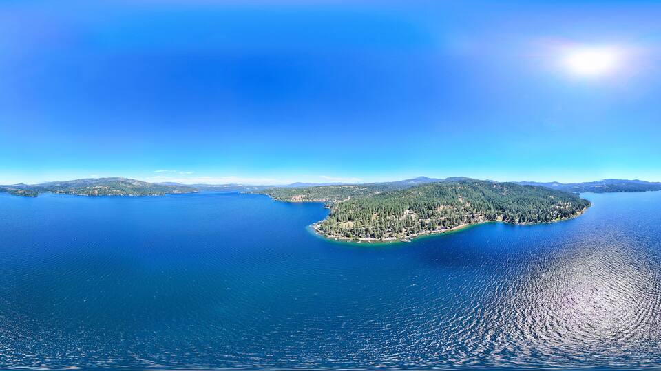 A large body of water with a small island covered in greenery.