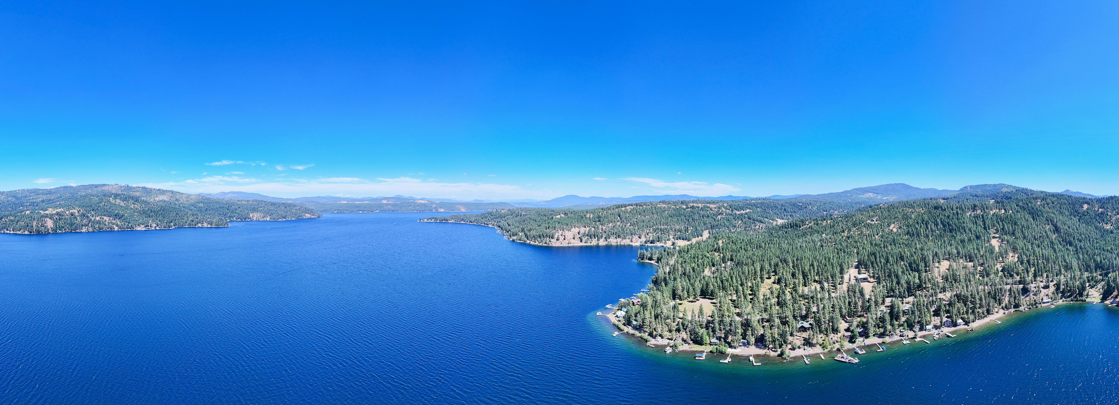 Aerial view captured by drone of the deep blue water at lake coeur d'alene in Harrison, Idaho. The water is calm and is a popular tourist destination for water sports. 
